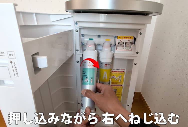 ハミングウォーター浄水フィルターBを押し込みながら右へねじ込んでいるところ