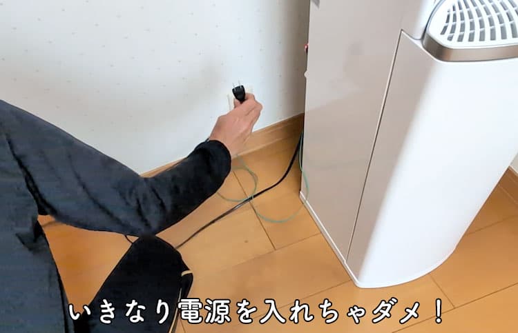 ハミングウォーターの電源プラグを持っているところ