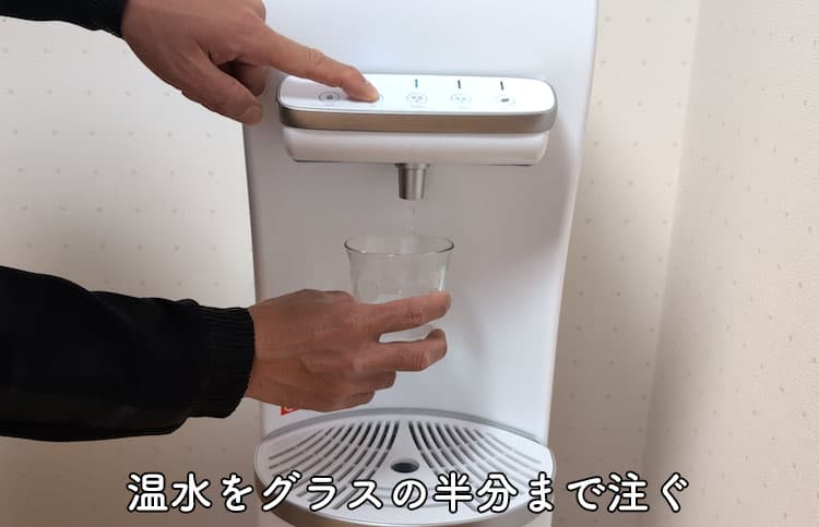 ハミングウォーターの温水をグラスの半分まで注いでいるところ